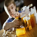 Child playing with pills and pill bottles on a table in front of them
